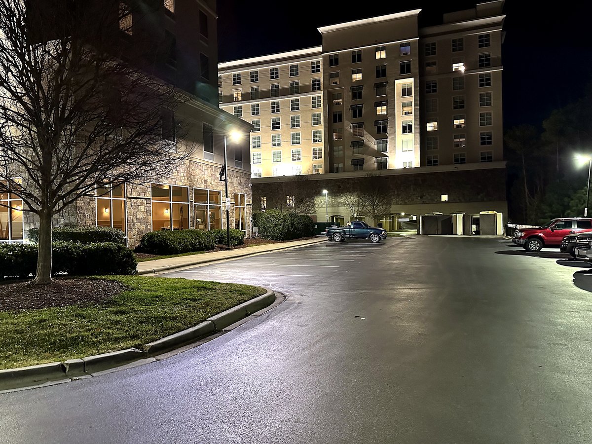 Hotel exterior with parking area lighting at night